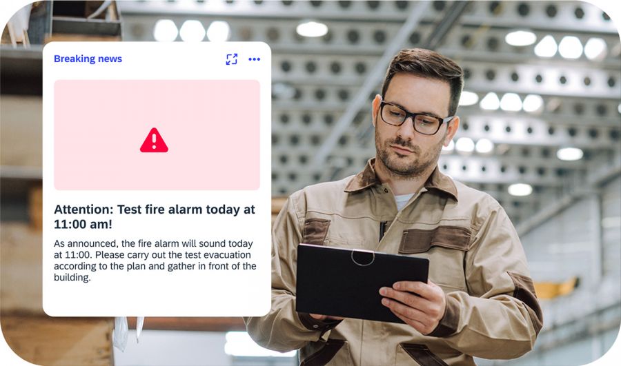 Production worker with tablet reads breaking news about fire alarm test in iNFOHUB