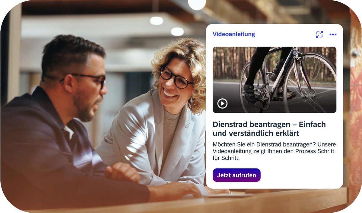 Kollegen im Gespräch mit iNFOHUB-Videoanleitung zur Dienstradbeantragung im Hintergrund