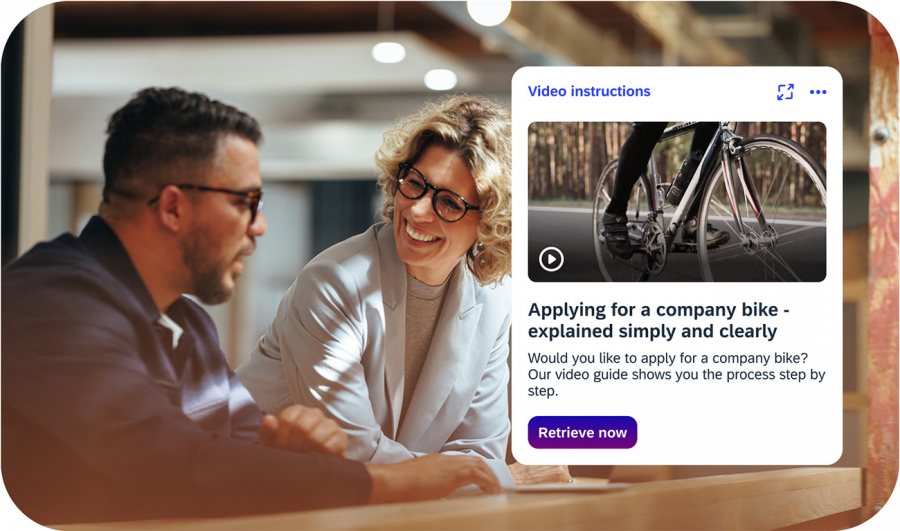 Colleagues in conversation with iNFOHUB video instructions for applying for a company bike in the background